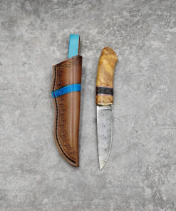 A fixed blade Damascus knife, displayed next to its leather sheath.