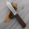 A fieldcraft knife displayed leaning against its Kydex sheath.