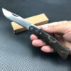 A man's hand holding a sharp pocket knife.