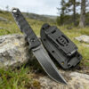 A sheath knife, displayed against a small rock, with a field background.
