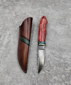 A deer caping wootz knife, displayed next to its sheath.