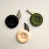 Three secret escape button knife models of differing color.