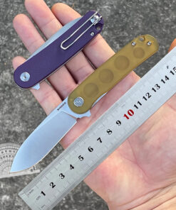 A man's hand holding a folding edc knife and steel ruler.
