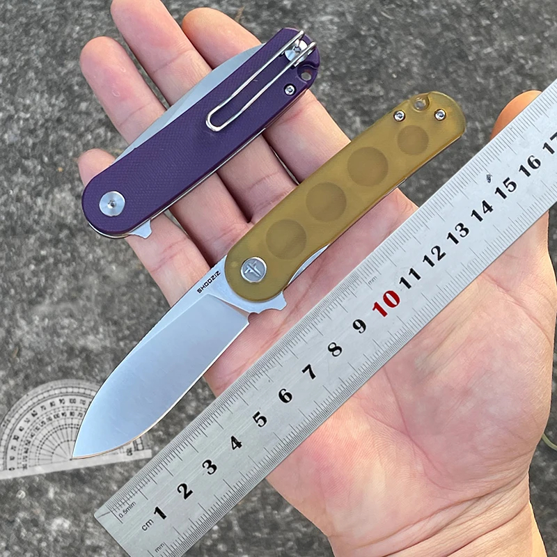 EDC Knife A man's hand holding a folding edc knife and steel ruler.