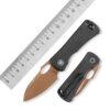 A small folding knife displayed next to a steel ruler.
