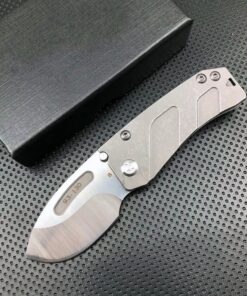 A small knife displayed next to a black box.