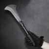 A man's hand holding a survival bill hook machete.