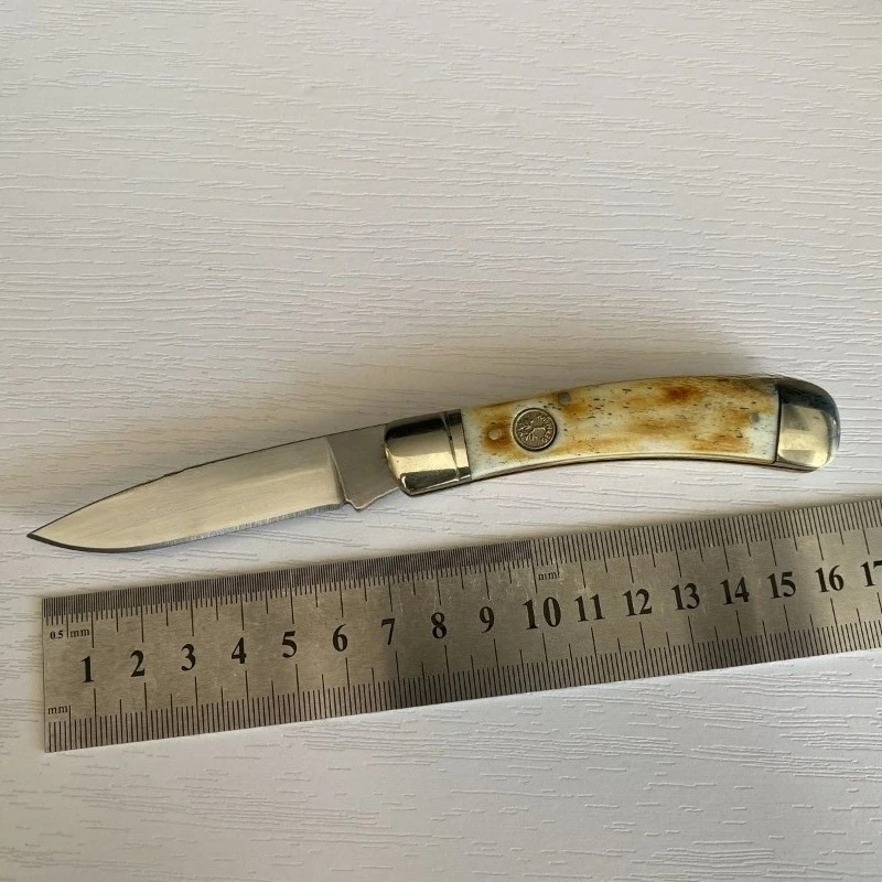 Bone Handle Pocket Knife A bone handle pocket knife displayed next to a steel ruler.