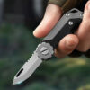 A man's hand golding a miniature keychain pocket knife.