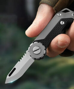 A man's hand golding a miniature keychain pocket knife.