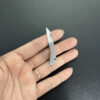 A woman's hand holding a tiny micro knife.