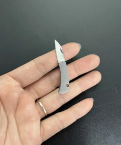 A woman's hand holding a tiny micro knife.