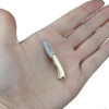 A tiny micro pocket knife resting in the palm of a man's hand.