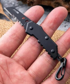 A man's hand holding a mini pocket knife keychain