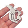 A multi tool keychain knife displayed on a man's fingertips.