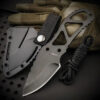 A mini knife necklace, displayed next to its small sheath.