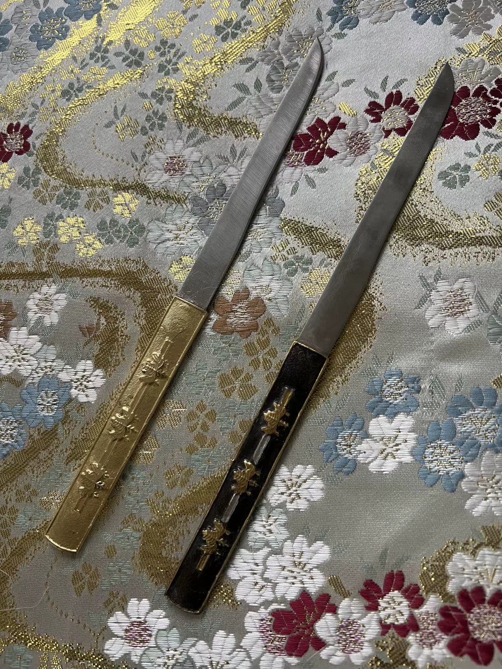 Small Japanese Knife Two Kogatana small Japanese knife models displayed against silk cloth.