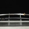 A black dragon Katana sword, displayed on a small stand alongside its scabbard.