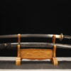 A dragon Katana sword, displayed on a wooden stand alongside its scabbard.