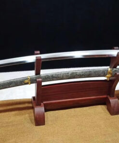 A hand forged Tamahagane Katana, displayed on a woden stand, alongside its scabbard.