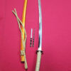 A hand forged Tamahagane steel Katana displayed next to its scabbard, Kogai hair needle and Kogatana knife.