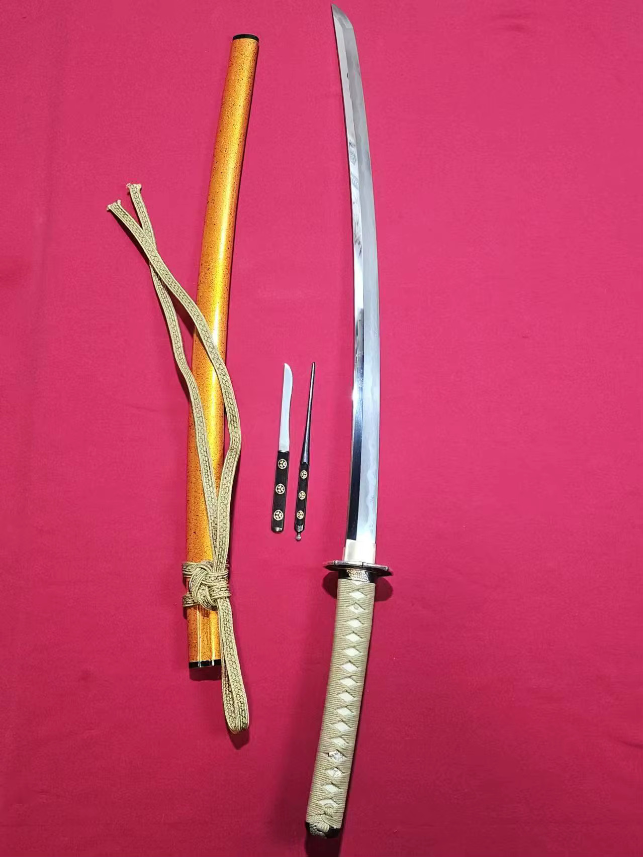 Tamahagane Steel Katana A hand forged Tamahagane steel Katana displayed next to its scabbard, Kogai hair needle and Kogatana knife.