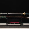 A true dragon sword Katana, displayed on a wooden stand alongside its scabbard.